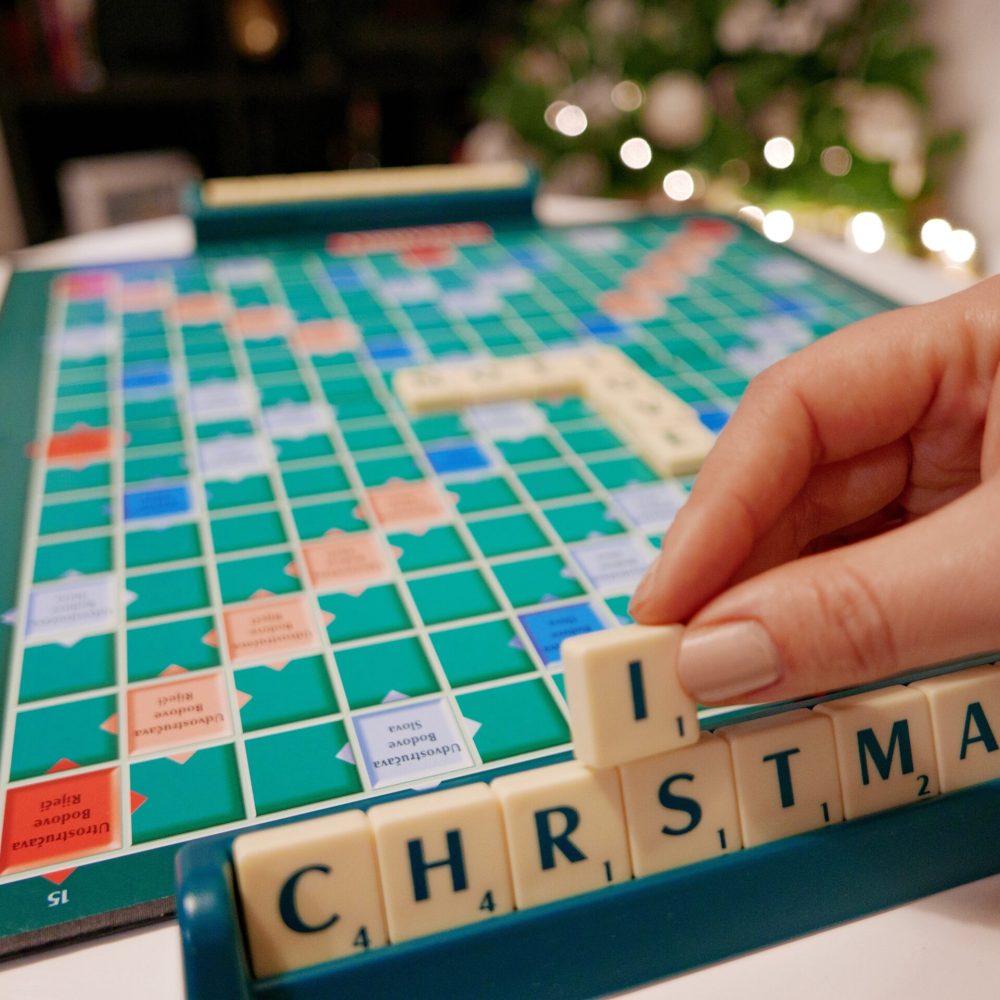 scrabble-board-game-on-table-hand-holding-letter-2025-03-09-06-43-57-utc